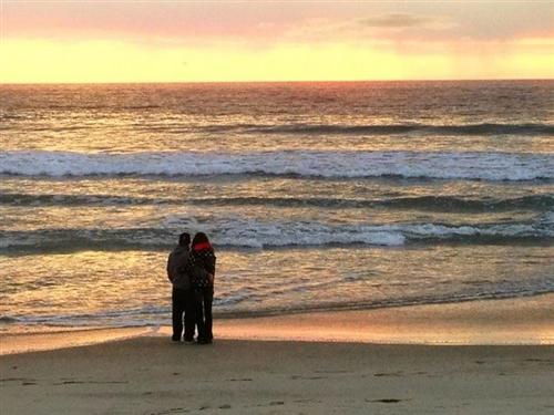 beach two people at sunset looking at the caifornia beach